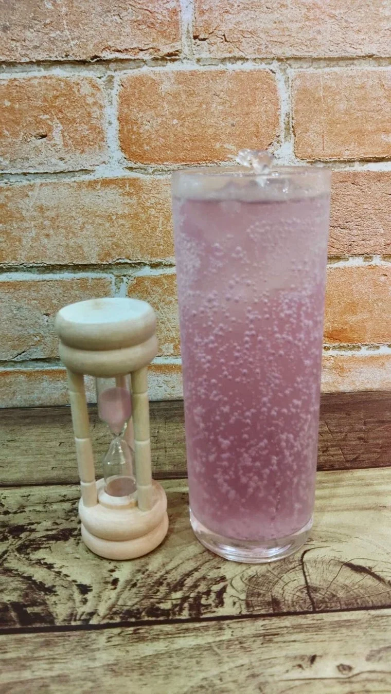 紫色の炭酸飲料と小さな砂時計