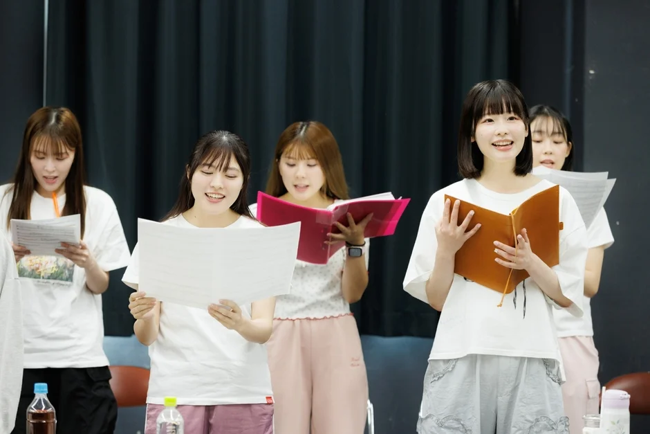 歌の練習をする若い女性グループ