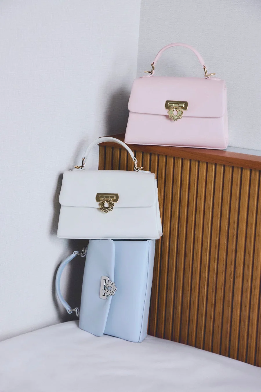 ピンク、白、水色の3つのパステルカラーのハンドバッグ