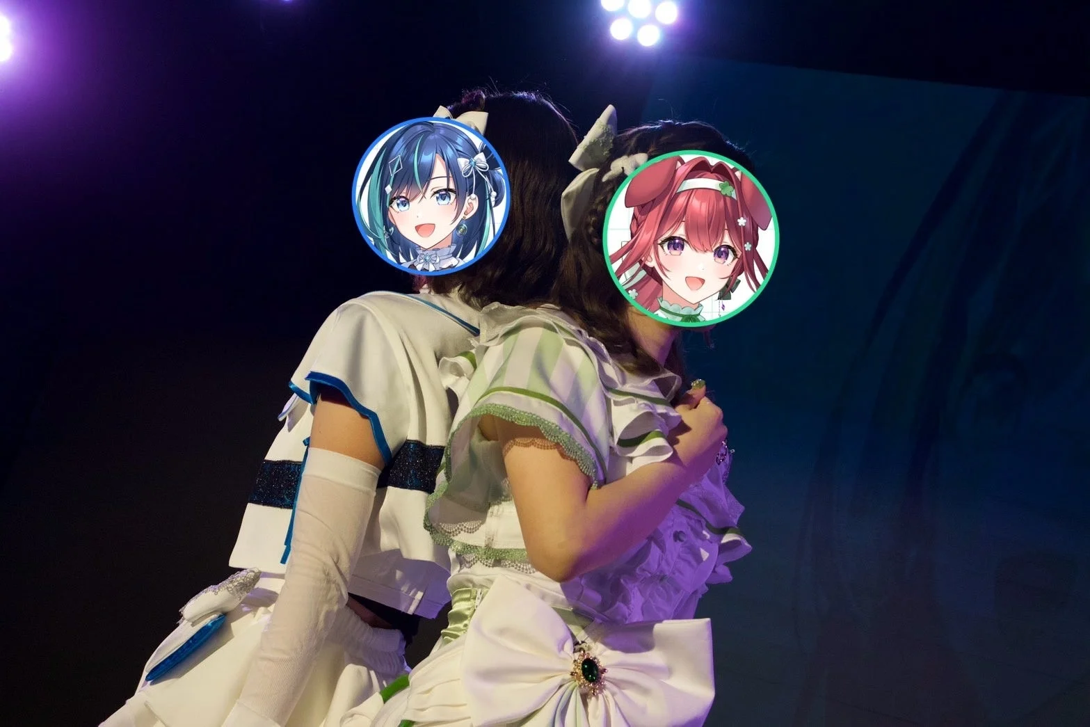 ステージ上で華やかな衣装をまとった2人の人物が背中合わせに立っています。