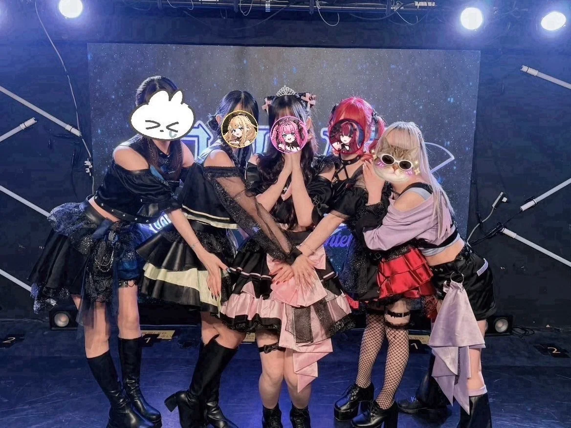 ライブステージでポーズをとる5人の女性グループ